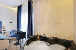 a room with a bath tub and a table and chairs at Couples Getaway Unit with Jacuzzi - City Center in Paris