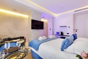 a hotel room with a large bed and a bathroom at Couples Getaway Unit with Jacuzzi - City Center in Paris