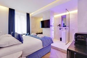 a bedroom with a large bed and a shower at Couples Getaway Unit with Jacuzzi - City Center in Paris