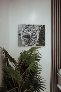 a picture hanging on a wall next to a plant at Najma's villa in Stone Town