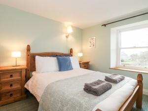 a bedroom with a bed with two towels on it at The Nook in Kirkoswald
