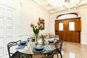 un comedor con una mesa de cristal con un jarrón de flores en Navona Artist 7 APT, en Roma