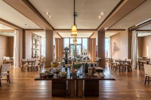 a dining room with tables and chairs and windows at Enjoy Puerto Varas in Puerto Varas