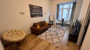 a living room with a couch and a chair at Cozy South-Up and Ground in Brussels