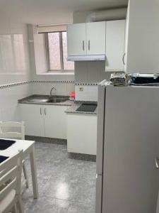 卡里尼奧的住宿－Acogedor piso en Cariño，厨房配有白色橱柜和白色冰箱。
