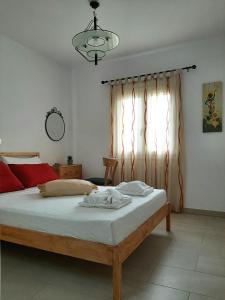 a bedroom with a bed and a window at Quiet, colourful home in Cyclades in Konizopí