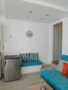 sala de estar con banco azul y ventana en Quiet, colourful home in Cyclades, en Konizopí