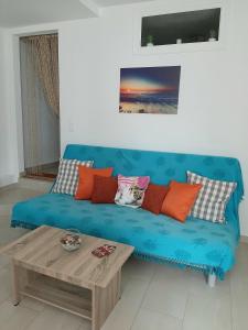 Sofá azul en la sala de estar con mesa de centro en Quiet, colourful home in Cyclades, en Konizopí