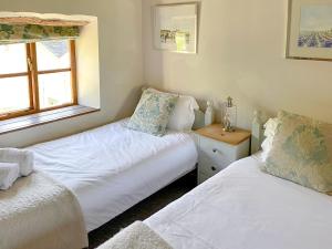 a bedroom with two beds and a window at The Pound House in Paignton