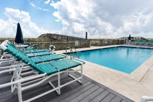 a pool with chaise lounge chairs and a swimming pool at Emerald Surf 102 in Navarre