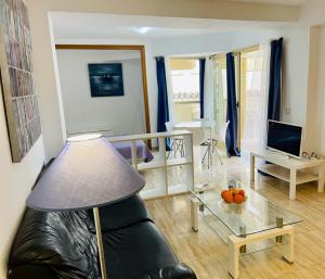 een woonkamer met een bank en een glazen tafel bij Puerta del Sol TRM only adults Aparts in Torremolinos