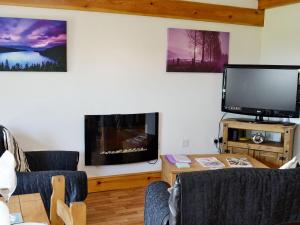 uma sala de estar com uma televisão de ecrã plano e uma mesa em Pheasant Cottage - Ukc3428 em Dalston