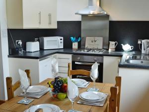 uma cozinha com uma mesa com uma taça de fruta em Pheasant Cottage - Ukc3428 em Dalston