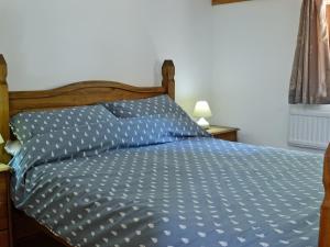 um quarto com uma cama com um edredão azul em Pheasant Cottage - Ukc3428 em Dalston
