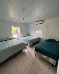 Habitación con 2 camas en una habitación en El Chalet del Canche, en Iztapa