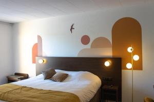 a bedroom with a large bed with white sheets at Logis Hôtel & Restaurant - Le Relais de Montigny in Montigny