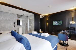 a large bedroom with two beds and a television at Couples Getaway Unit with Jacuzzi - City Center in Paris