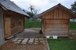 un pequeño edificio junto a un cobertizo con patio en Glamping Organic Farm Slibar en Tržič