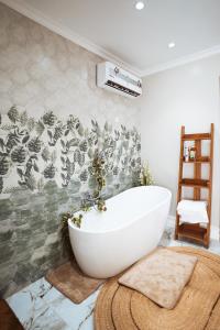 baño con bañera blanca en la pared en Najma's villa en Stone Town