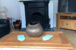 un jarrón sobre una mesa de madera en la sala de estar en Bumblebee Cottage, en Donegal