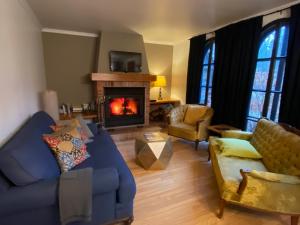 a living room with a blue couch and a fireplace at L'enchantement Vacation home by Rendez-Vous Mont-Tremblant in Mont-Tremblant