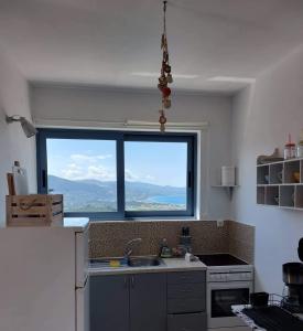 a kitchen with a sink and a large window at Villa Thea - The View 2nd floor in Áno Yerakaríon