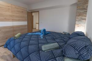 a bed with a blue comforter in a room at Apartma Valič in Ajdovščina