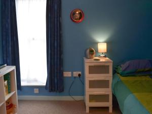 a bedroom with blue walls and a bed with a lamp at The Bait Shed in Filey