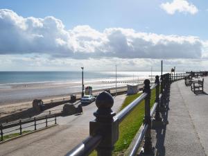 a view of a beach with a fence and the ocean at The Bait Shed in Filey