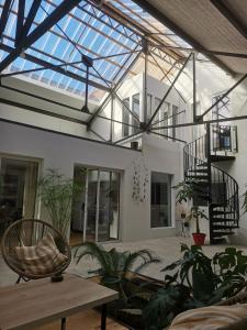 un salón acristalado con techo de cristal con plantas y mesa en Shamshouse/Garage, en Dol-de-Bretagne