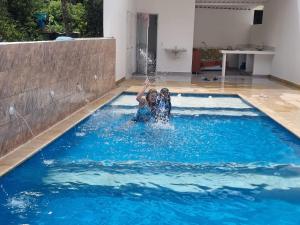 two people in a swimming pool with water shooting into the air at CASA CAMPESTRE LA ESMERALDA in Melgar