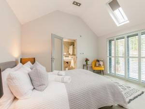 a white bedroom with a large bed with white pillows at Home Barn in Lyminge