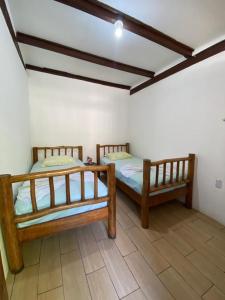 two wooden beds in a room with a floor at Casa de la Iguana in Lívingston