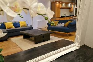 a mirror in a living room with a couch and a table at Stunning Luxury 2 Bed Penthouse Apartment in Derby