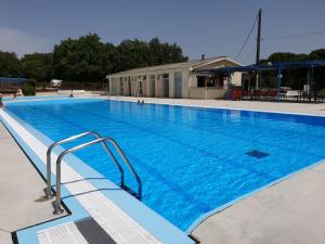 Limogne-en-QuercyCAMPING LE BEL AIR mobil home LE CORNOUILLER 4 personnes的一个蓝色海水的大型游泳池