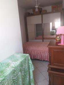 een slaapkamer met een bed, een dressoir en een spiegel bij Apartamento perto da praia de Itaparica in Vila Velha