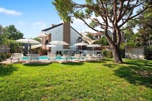 una casa con piscina, sillas y sombrillas en Villa La palmetta, en Peschiera Borromeo
