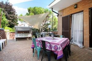 eine Terrasse mit einem Tisch, Stühlen und einem Grill in der Unterkunft Villa La palmetta in Peschiera Borromeo