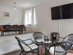 a living room with chairs and a flat screen tv at Carlton House in Hazel Grove