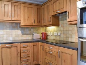 a kitchen with wooden cabinets and a red appliance at Carlton House in Hazel Grove