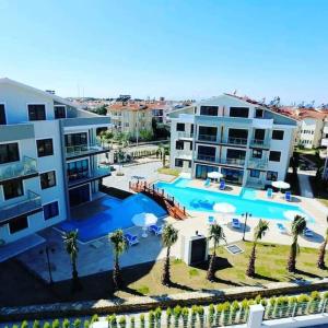 an apartment complex with a swimming pool and palm trees at Mountainview residency in Belek