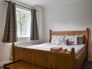 a bedroom with a wooden bed with a window at Carlton House in Hazel Grove