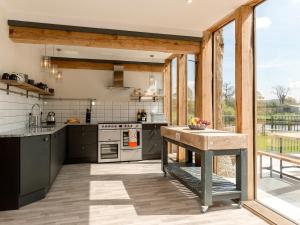 a kitchen with stainless steel appliances and a large window at East Dunster Deer Farm Linny in Cadeleigh