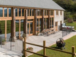 a house with glass walls and a patio at East Dunster Deer Farm Linny in Cadeleigh