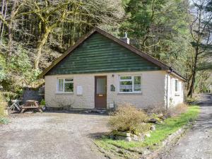 a small white house with a picnic table in front of it at The Glen in Devils Bridge