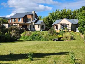 a house on a hill with a yard at Boutique Art Retreat in Upper Hutt