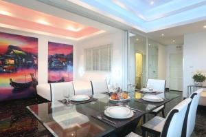 a dining room with a table and white chairs at PATONG TOWER FAMILY SEA VIEW by PTA in Patong Beach