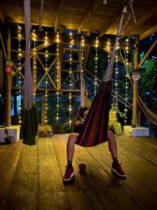 a person sitting in a hammock in a room at Casa de la Iguana in Lívingston