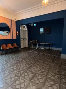 a room with a blue wall with a table and chairs at The Blue Piano Guesthouse in Birmingham