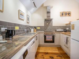 a large kitchen with white cabinets and a sink at The Milking Parlour in Llangeler